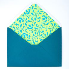 5x7 handmade envelope in teal with a decorative floral liner in yellow and aqua, shown open with flap up.