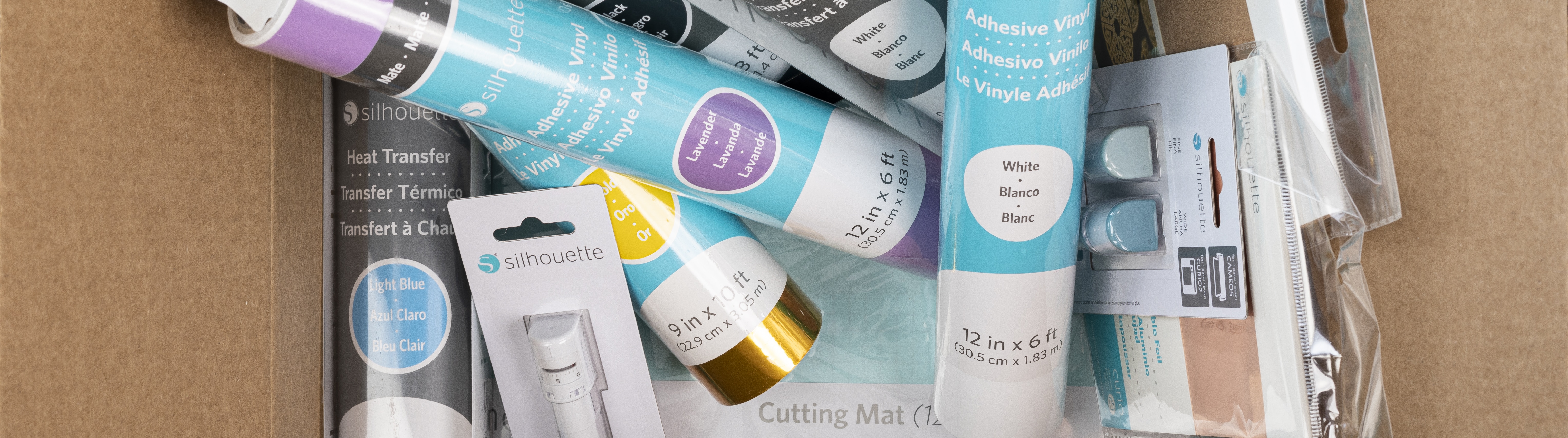 Silhouette cutting machine surrounded by various types of adhesive vinyl 
