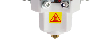 Close-up of a 3D printer nozzle assembly with a yellow warning label indicating a hot surface.