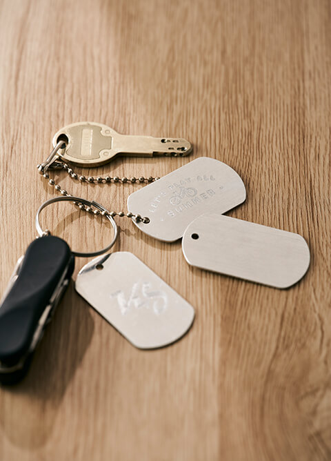 The keychain includes a brass key, a black multi-tool