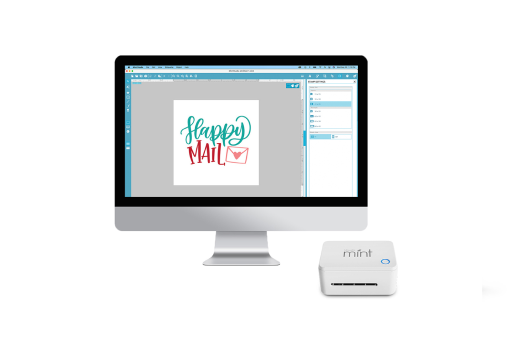 A white Silhouette Mint machine next to a computer monitor displaying a design software interface with the text 'Happy Mail' and a small envelope icon.