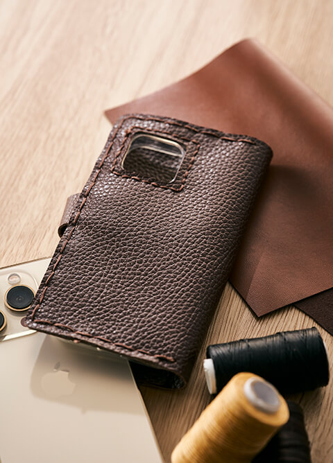 A brown leather phone case with visible stitching,