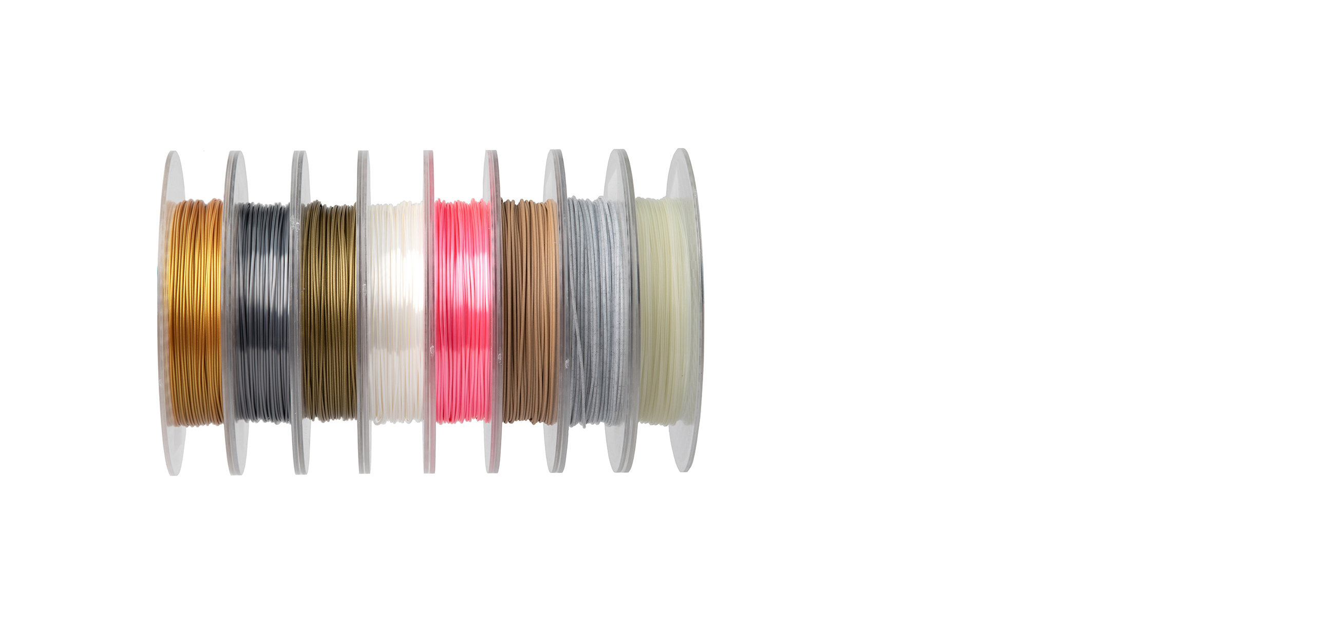Spools of specialty 3D printer filament in various colors and finishes, including gold, silver, white, pink, bronze, and metallic hues, arranged side by side.